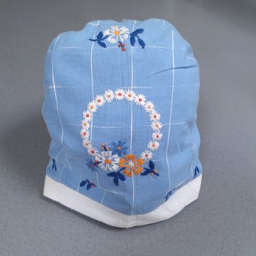 Kaffeewärmer 30x32 Leinen, hellblau, weißes Karoraster, 3 weiße Blütenkränze aufgestickt, weißer Rand
