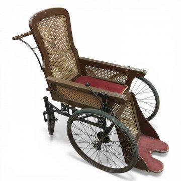 Rollstuhl, braun lackiert, Rücken/Fußbank Rohrgeflecht, Sitzpolster Velours dkl.rot, Griff, Metallgestell, Speichenräder